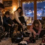 Vacances en famille pour Noël : famille retire ses bottes près du chalet